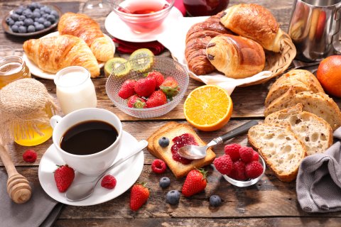 Ein großes leckeres Frühstück mit Kaffee, Croissant und verschiedenen Obstsorten.