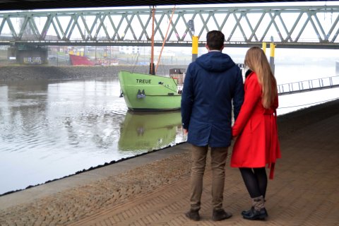 Ein Pärchen vor dem Schiff Treue an der Weser