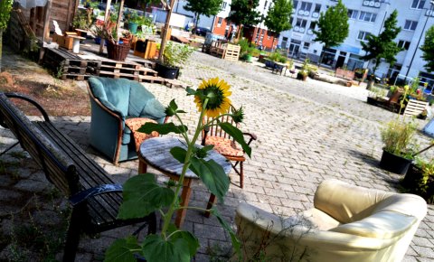 Sitzgruppe mit Sesseln und einer Bank im urbanen Garten 'Lucie' in der Neustadt