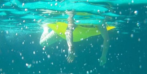 Kinderbeine unter Wasser mit Luftmatratze