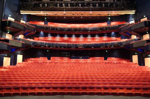 Eine Innenaufnahme des Metropol Theaters Bremen. Ein Blick von der Bühne in den großen Theatersaal mit roten Stühlen.