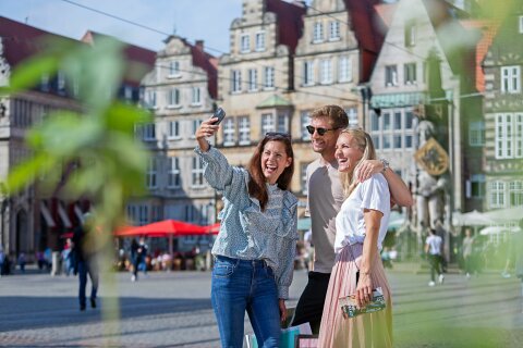 drei Personen stehen auf dem Bremer Marktplatz und machen ein Selfie