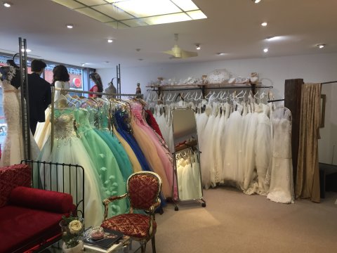 Blick in einen Laden mit weißen und bunten Hochzeitskleidern