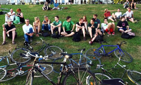 Menschen sitzen am Osterdeich, vor ihnen ihre Fahrräder im Gras.