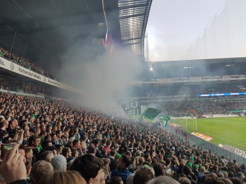 Zu sehen sind Fans in der Ostkurve im Weserstadion. Die Fans feuern Werder Bremen an.