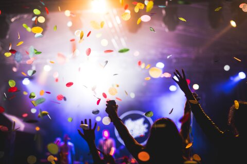 A crowd is dancing, with their hands in the air.