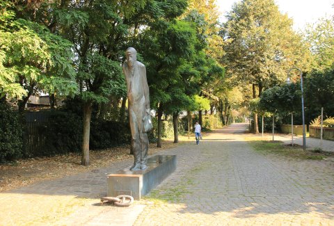 Die Bronze-Skulptur Zur Schicht steht in Gröpelingen an der Lindenhofstraße, Ecke Dockstraße.