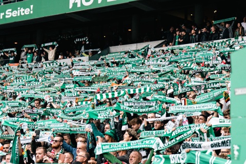 Hunderte Fans halten ihren Werderschal in die Luft. 