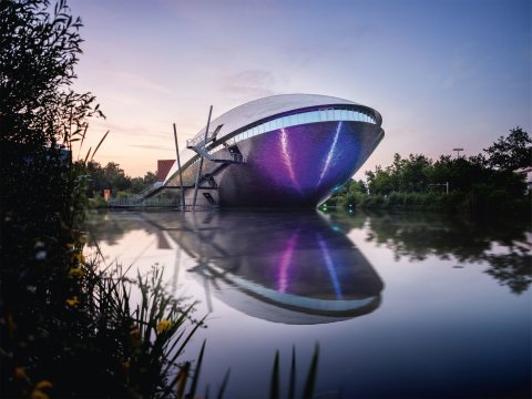 Ein futuristisches Gebäude mit einem See