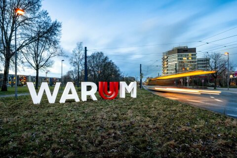Zu sehen ist der Schriftzug "Warum" vor dem Gebäude der Universität Bremen. Er gehört zu der Ausstellung "WARUM? DARUM!" der Uni Bremen