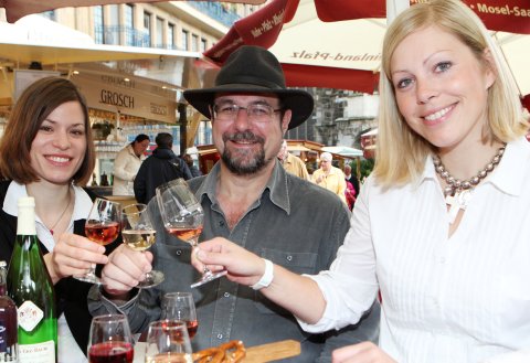 Eine Gruppe Menschen genießen Wein auf dem WeinSommer-Fest