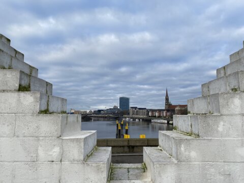 Blick auf die Weser - Links und rechts befinden sich weiße Backsteine, die wie Treppenstufen angeordnet sind.