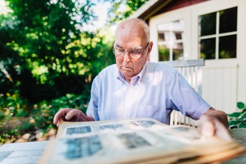 Dr. Diethelm Knauf mit einem dicken Buch im Garten