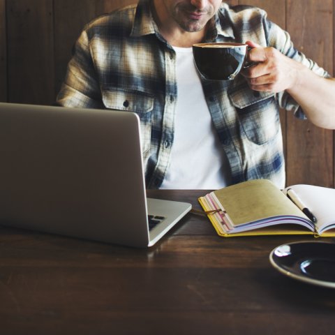 Bild von einem Mann mit Laptop in einem Café