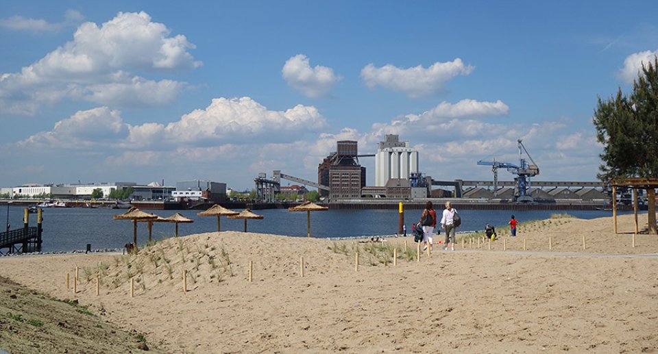 Blick auf den Waller Sand, einem Stadtstrand mit Blick auf die Hafenkulisse in der Bremer Überseestadt