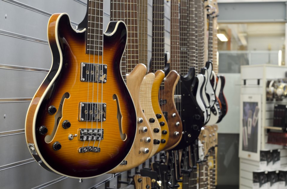 Viele Gitarren die an einer Ladenwand aufgehängt wurden