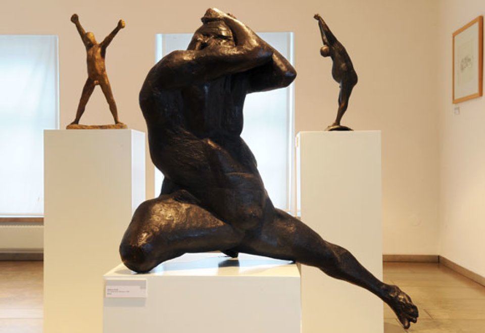 Drei Bronzefiguren von Gerhard Marcks - Grizmek. Die Figur im Vordergrund hat eine athletische Pose mit gespreizten Beinen.