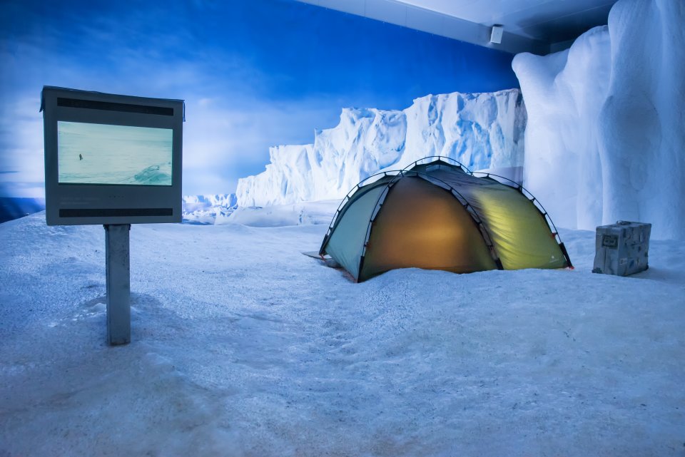Der Ausstellungsraum ist der Antarktis nachempfunden. Ein Zelt steht im künstlichen Schnee. 