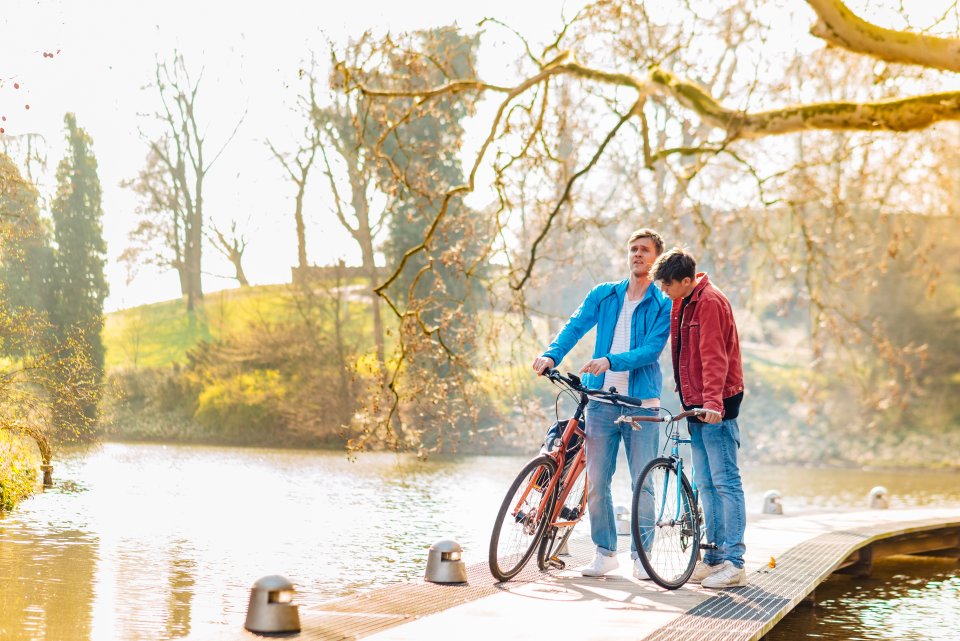 Zwei Männer stehen mit ihren Fahrrädern auf einer Brücke