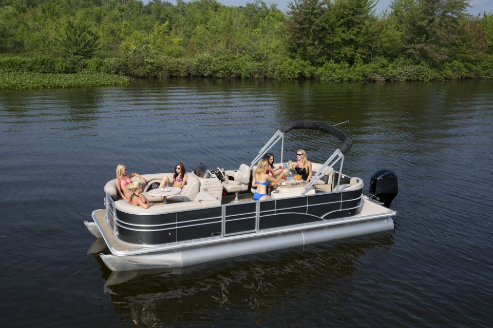 Eine Gruppe von Frauen sitzt bei Sonnenschein in einem Boot. 