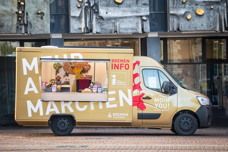 Das Bremen Mobil, ein Gold lackiertes Fahrzeug aus dem heraus an Bremen interessierte Menschen beraten werden, steht vor der Fassade der Bremer Bürgerschaft.