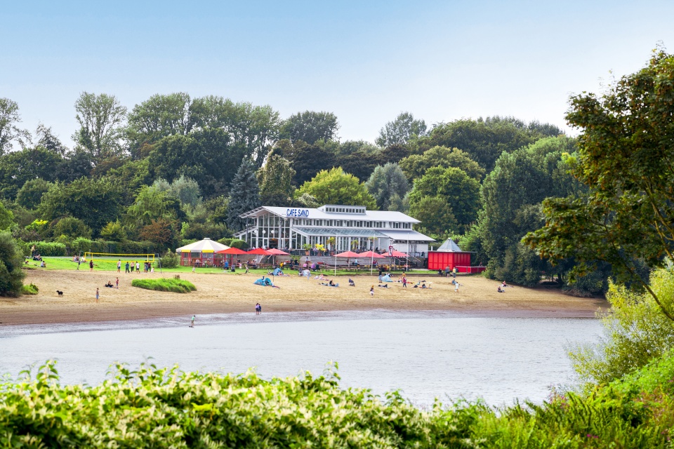 Auf der anderen Weserseite liegt an einem kleinen Sandstrand ein Café.