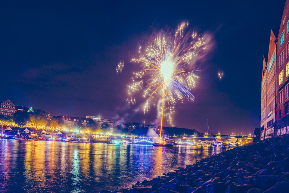 Die Schlachte ist bunt beleuchtet und ein Feuerwerk fliegt in den Himmel. 