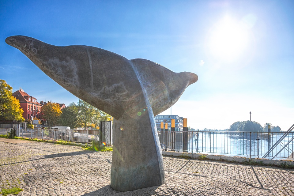 Whale tail sculpture by the riverside in Vegesack on a sunny day.