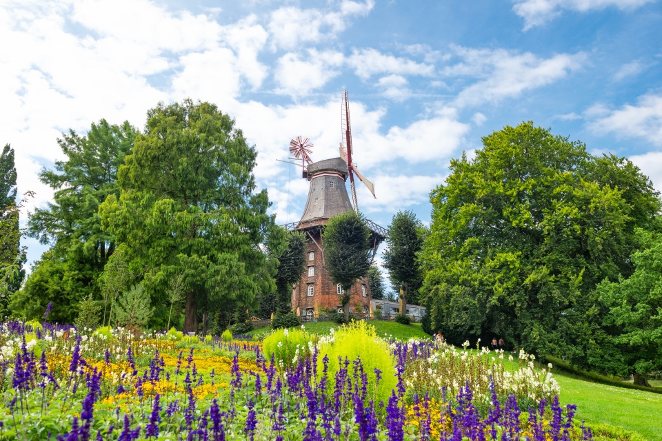 The mill at the Wallanlagen. There are numerous flowers in the foreground. 