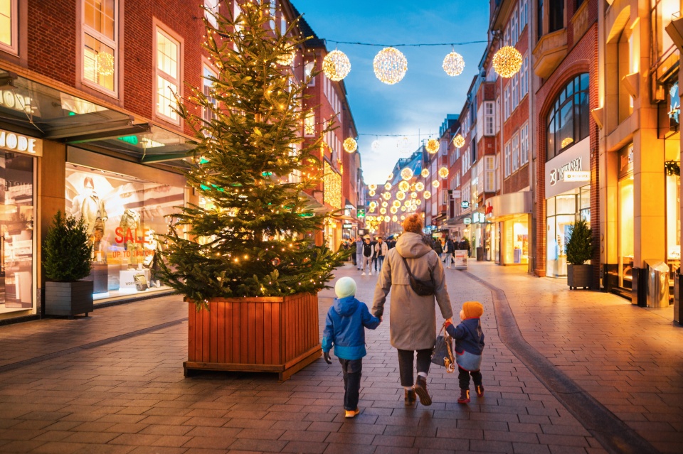 Eine Familie schlendert durch die weihnachtlich beleuchtete Sögestraße