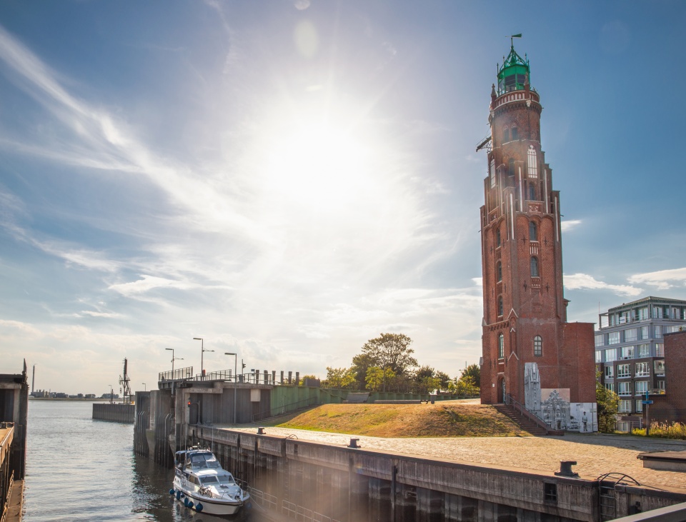 Ein Leuchtturm steht an einer Schleuse.