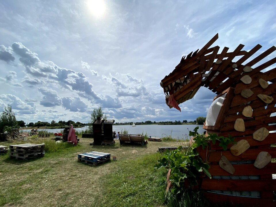 Menschen sitzen beim Projekt "Die komplette Palette" auf Palettenmöbeln und genießen den Blick auf die Weser