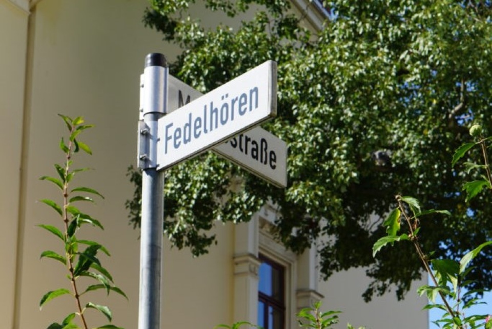 Zu sehen ist ein Straßenschild auf dem Fedelhören steht.