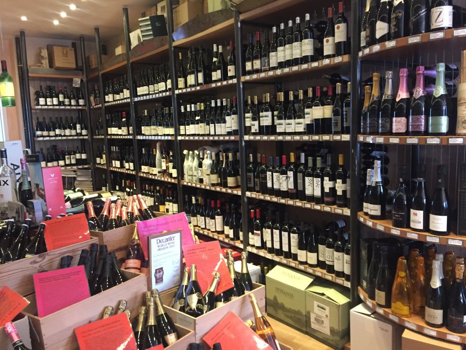 Blick auf ein Weinregal mit Rotweinen in einem Weinladen