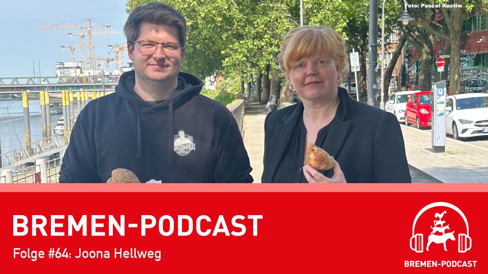 Ein Mann und eine Frau stehen mit einem Kaneelbrötchen an der Schlachte.