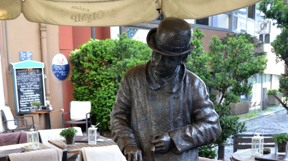 A bronze statue of a man with a hat.