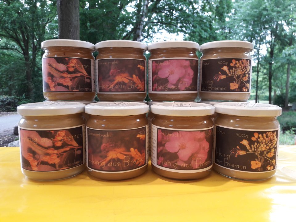 Gestapelte Honiggläser mit verschiedenen Honigsorten: Lindenhonig, Sommertracht, Frühtracht und Raps.
