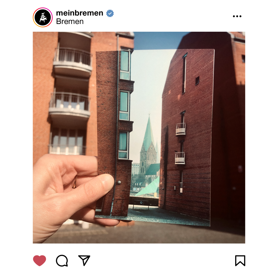 Eine Hand hält ein analoges Foto ins Bild: Es zeigt Gebäude auf dem sogenannten "Teerhof" in Bremen und fügt sich damit in den Hintergrund des Gesamtbildes, das ebenfalls den Teerhof zeigt - Ein Bild im Bild.