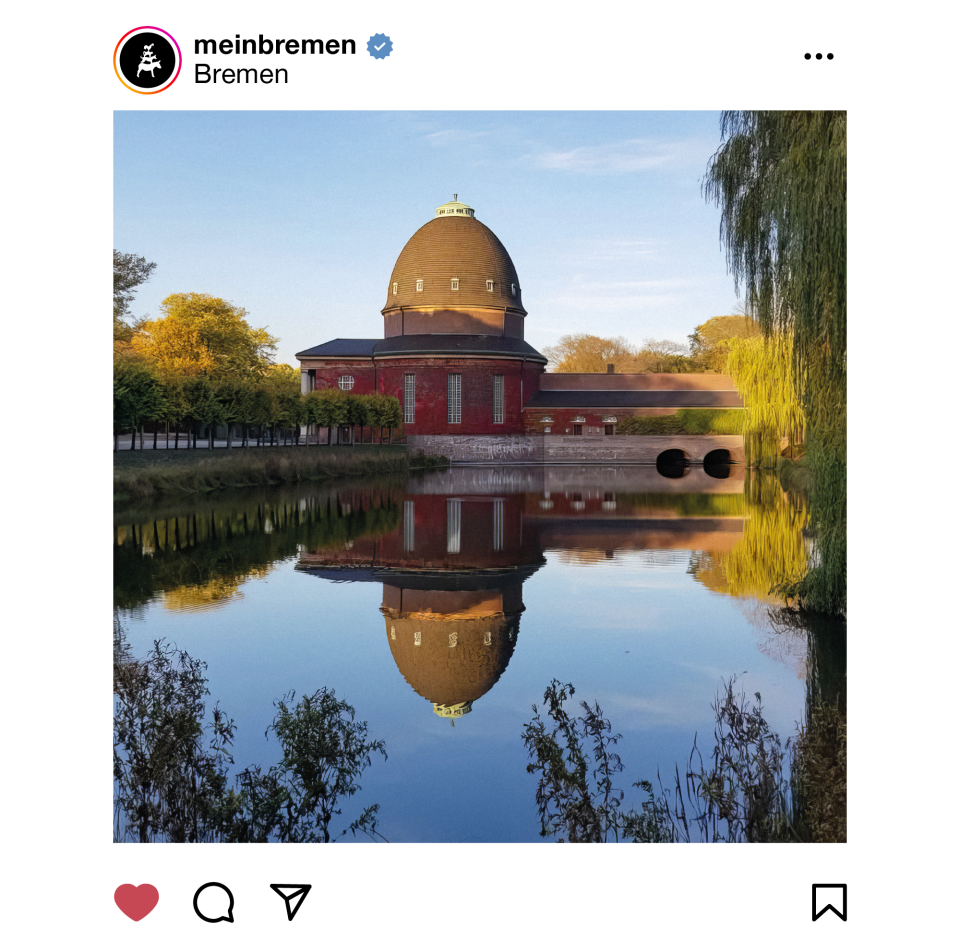 Ein Krematorium auf einem Friedhof. Es spiegelt sich in einem kleinen Teich.