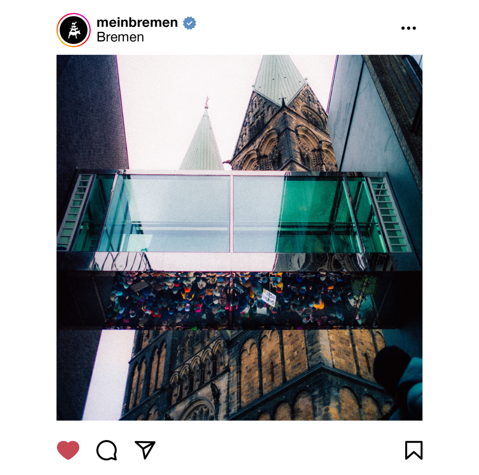 Eine Demonstration spiegelt sich in einem gläserneren Übergang. Im Hintergrund ist der St. Petri Dom zu sehen.