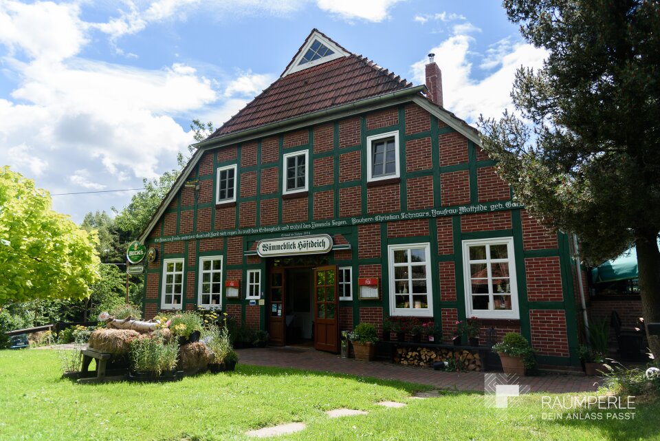 Außenansicht des alten Bauernhaus mit Grünfläche davor.