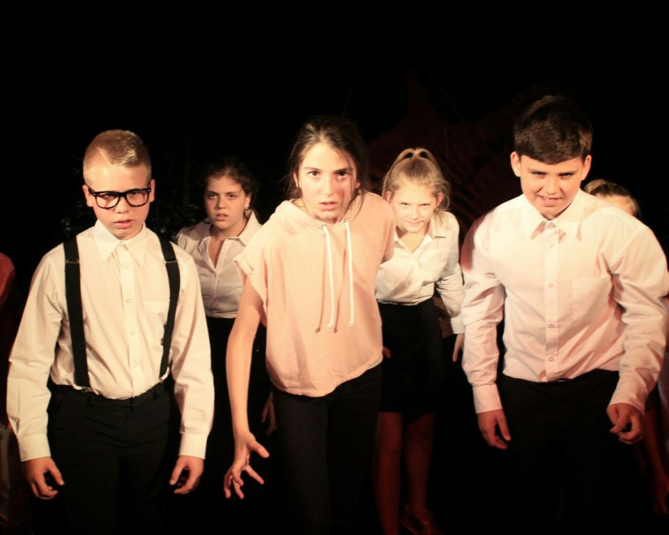 Eine Szene aus dem Theater elf Stück "Reine Herzen". Fünf junge Schauspieler laufen ernst auf die Kamera zu